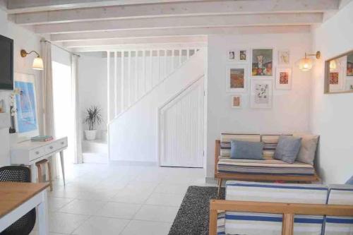 uma sala de estar branca com um sofá e uma mesa em Casa de férias Óbidos em Óbidos