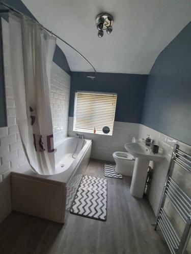 a bathroom with a tub and a toilet and a sink at Private RoomB Middleton Manchester in Middleton