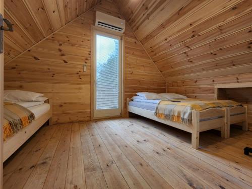 2 camas en una cabaña de madera con ventana en Agro-Gala en Rabka