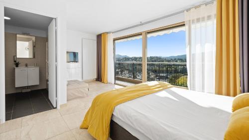 a bedroom with a bed and a large window at Cannes Marina Appart Hotel Mandelieu in Mandelieu-la-Napoule
