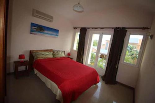 - une chambre avec un lit rouge et une fenêtre dans l'établissement Magnifique Villa avec piscine privée à 550 m de la plage, à Trou aux Biches