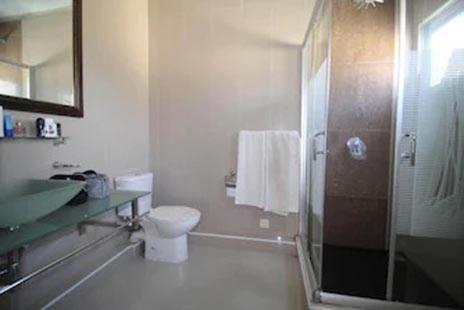 a bathroom with a toilet and a sink and a shower at Villa Begonia - Magnifique Villa avec piscine privée à 550 m de la plage in Trou aux Biches