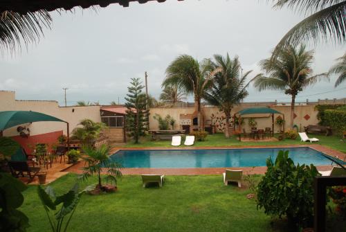 un complejo con piscina y palmeras en Residenza Canoa, en Canoa Quebrada
