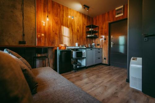 a kitchen with wooden walls and a couch in a room at Apartamenty Garncarska 3 in Środa Wielkopolska