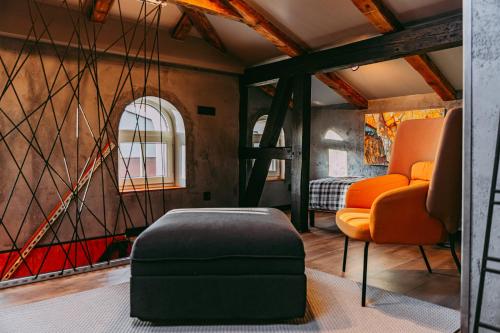 Habitación con 2 sillas de color naranja y reposapiés en Apartamenty Garncarska 3 en Środa Wielkopolska
