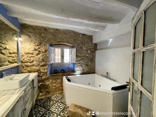 a bathroom with a bath tub and a sink at El Secret de la LLegenda El Drac in Vilavert