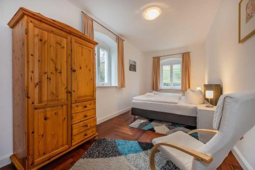 a bedroom with a bed and a cabinet and a chair at Villa Meereswoge 02 in Bansin
