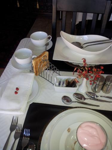 a table with plates and utensils on a table at Villa Xanelle Boutique Guest House in Centurion