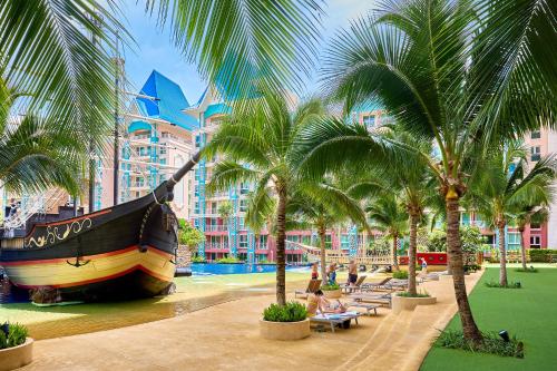 a large boat in the water next to palm trees at Grande Carribean sea view apartments Jomtien beach in Pattaya South