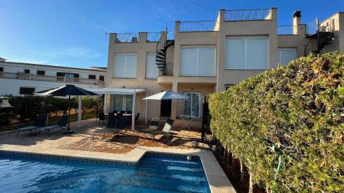 a house with a swimming pool next to a building at Aina in Cala Pi
