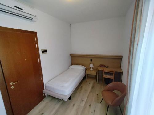 a small room with a bed and a desk and a chair at Hotel S.Maria in Brenzone sul Garda
