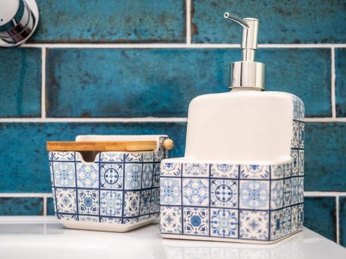 a soap dispenser and a container on a counter in a bathroom at B&B De Oude Skuur Texel in Oosterend