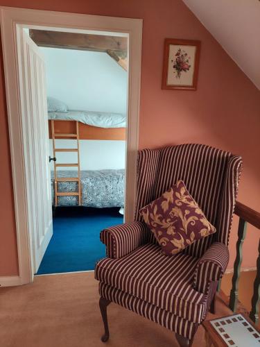 sala de estar con silla y escalera en The Manor House, Curry Mallet, en Taunton