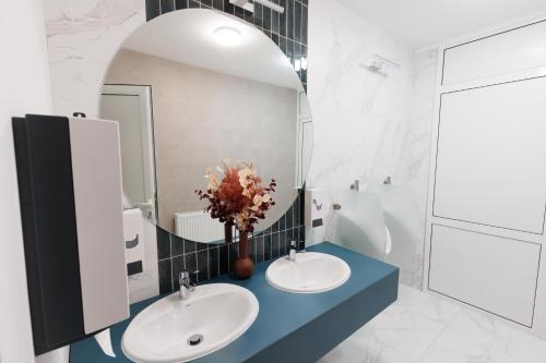 La salle de bains est pourvue de 2 lavabos et d'un miroir. dans l'établissement Hotel YVY, à Sebeş
