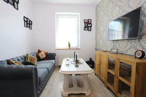 - un salon avec un canapé et une table dans l'établissement Apartament Winston, à Szczawno-Zdrój