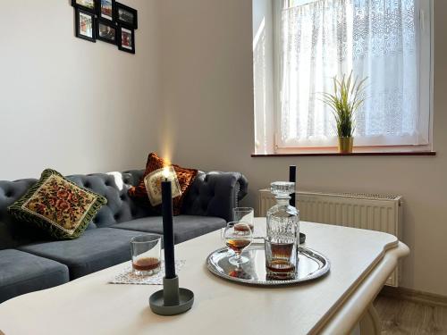 a living room with a table with glasses and a couch at Apartament Winston in Szczawno-Zdrój