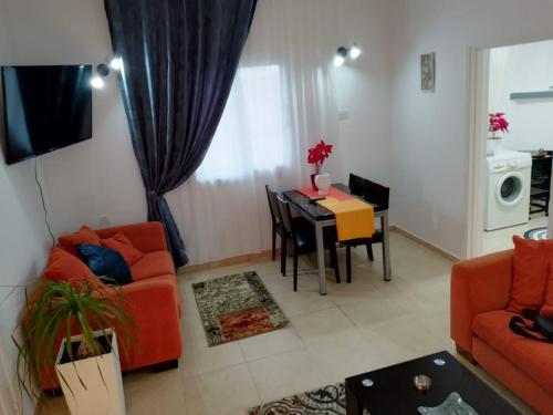 a living room with a orange couch and a table at Mountain Kathikas apartments in Kathikas