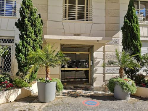 een gebouw met bomen en planten ervoor bij Croisette Immo 4 chambres 4 sdb rue d'Antibes in Cannes