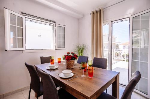 uma sala de jantar com uma mesa de madeira e cadeiras em Villy Suites em Argasi