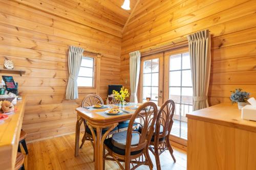 a wooden dining room with a table and chairs at Suite Villa Nasukogen Log MoiMoi in Nasu