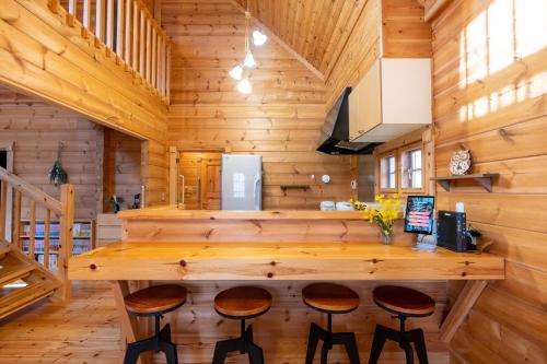 a kitchen with a large wooden bar in a log cabin at Suite Villa Nasukogen Log MoiMoi in Nasu