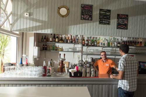 two men standing at a bar with a bartender at Villages Clubs du Soleil - RONCE LES BAINS in Ronce-les-Bains