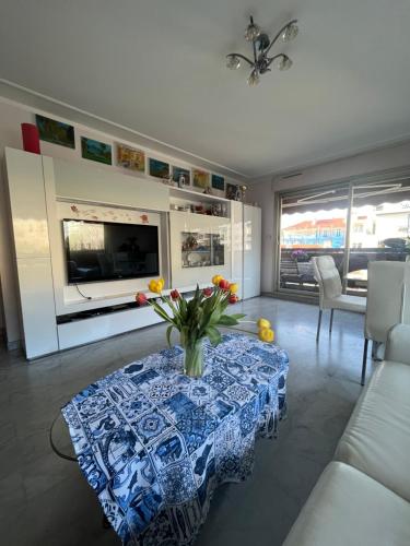 un salon avec une table avec un vase de fleurs dessus dans l'établissement Chambre privée avec terrasse au port de Nice, à Nice