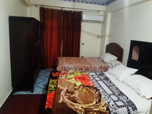 a small bedroom with two beds and a window at الميناء السياحي جزيرة القرنة in Luxor