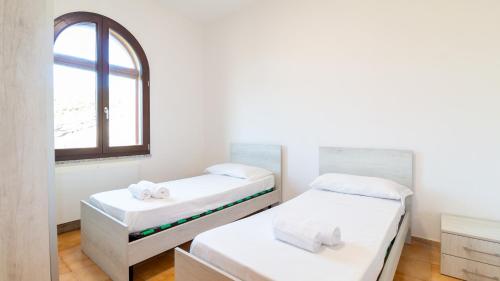 Duas camas num quarto com uma janela em La Rosa dei Venti-Panoramic View em S'archittu Cuglieri