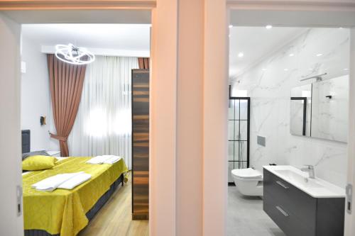 a bedroom with a yellow bed and a bathroom at RED MOON SUITES in Fethiye