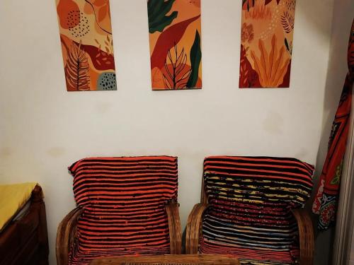 una habitación con 2 sillas y 4 pinturas en la pared en اللوكاندة الجديدة New Hotel en Alexandría