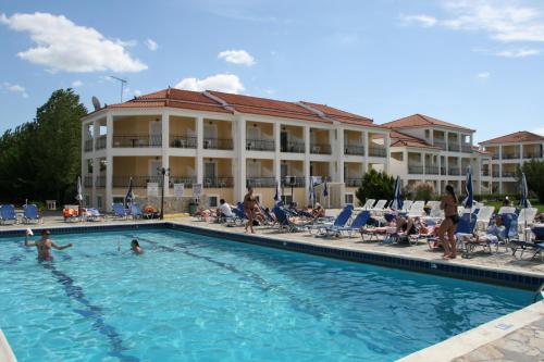 una piscina con gente en un hotel en Village Inn Studios & Family Apartments, en Laganas