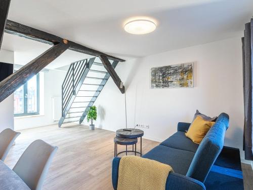a living room with a blue couch and a staircase at StadtQuartier im Stadtzentrum in Malchow