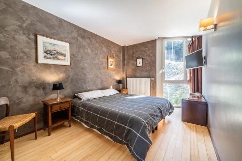 ein Schlafzimmer mit einem großen Bett und einem Fenster in der Unterkunft Gîte Le Jorat - Appartement A in Bogève