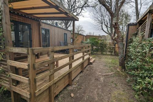 une clôture en bois devant une maison dans l'établissement Mobil-home Camping Biscarosse, à Biscarrosse
