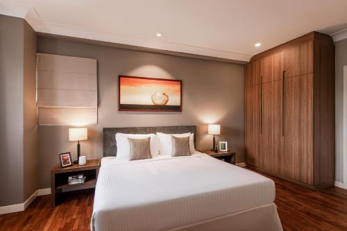 a bedroom with a large white bed and two lamps at Domitys Bangsar Kuala Lumpur in Kuala Lumpur