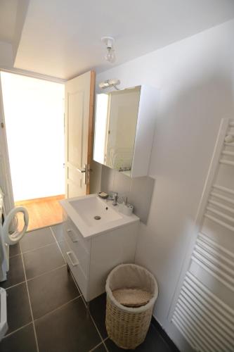 une salle de bain blanche avec un lavabo et un miroir dans l'établissement La Glycine Maison 1.5 km Veulettes sur mer, à Paluel