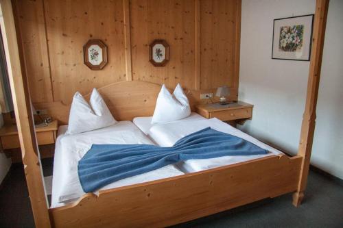 a wooden bed with a blue blanket on it at Ferienwohnungen "Kober" in Hopfgarten im Brixental
