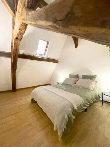 une chambre avec un grand lit dans un grenier dans l'établissement Atypique - Centre historique - Appartement 2 chambres, à Bourges