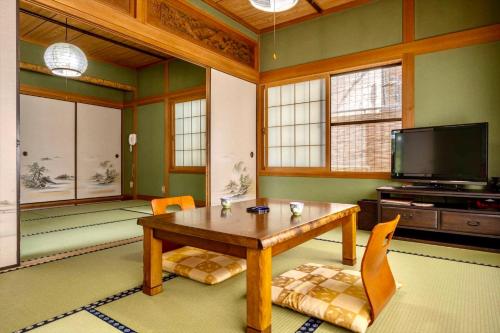 sala de estar con mesa de madera y TV en Ryosou Makibanoie 18 years or older en Yufuin