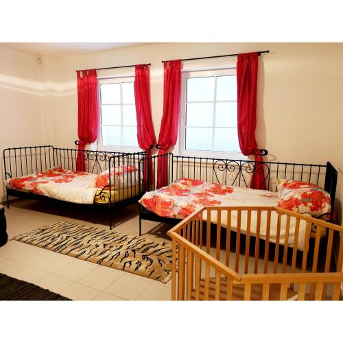 sypialnia z 2 łóżkami i czerwonymi zasłonami w obiekcie Haus am Stadtrand / Grünruhelage w Wiedniu
