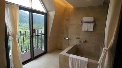 礁溪鄉的住宿－麗翔酒店連鎖-礁溪館，带淋浴和浴缸的浴室以及窗户