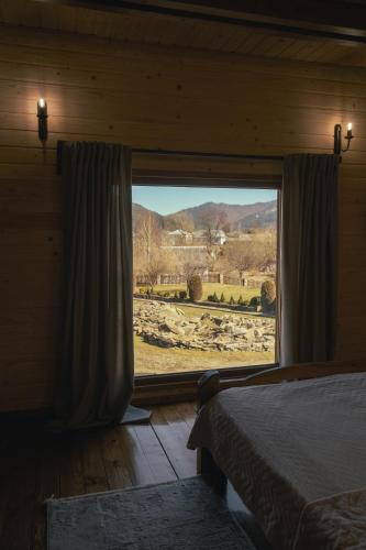 a bedroom with a large window with a view at VIGORA in Verkhovyna