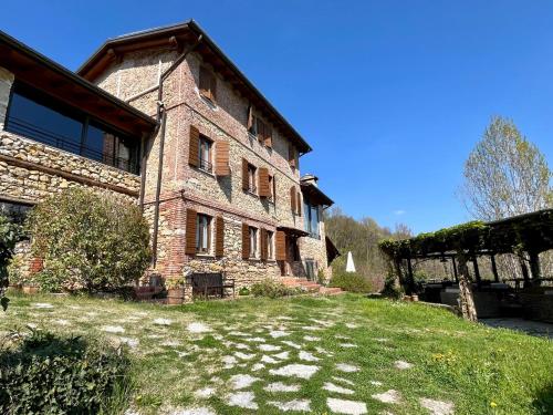 an old brick building with a grass yard in front of it at B&B A Casa Mia in Marostica