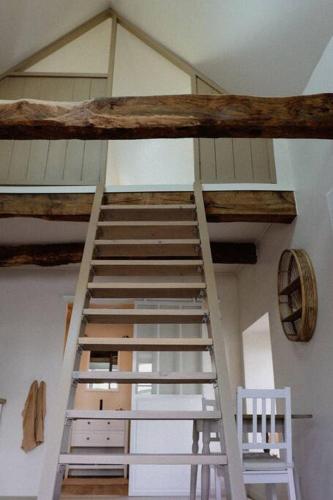 a ladder in a room with a ceiling at Ti Gwaskell, maison proche de Quimper in Landudal