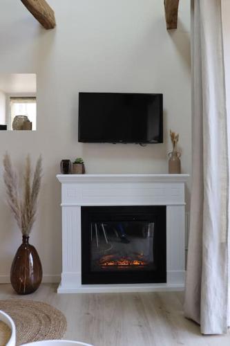 a living room with a fireplace with a television above it at Ti Gwaskell, maison proche de Quimper in Landudal