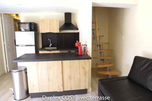a kitchen with a counter top and a refrigerator at Duplex cosy avec terrasse in Marseille