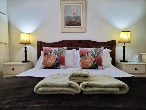a bedroom with a bed with a blanket and two lamps at Olive and Vine Farm Cottage in Franschhoek