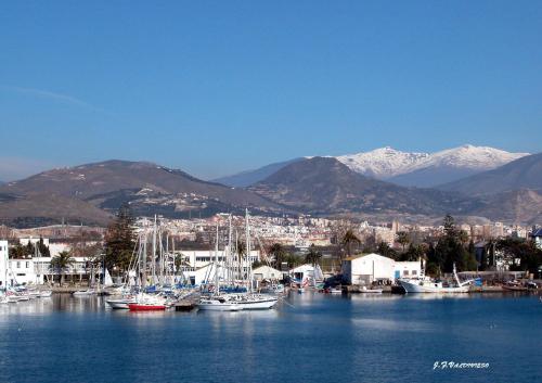 un grupo de barcos atracados en un puerto con montañas en Hostal la Campana, en Motril