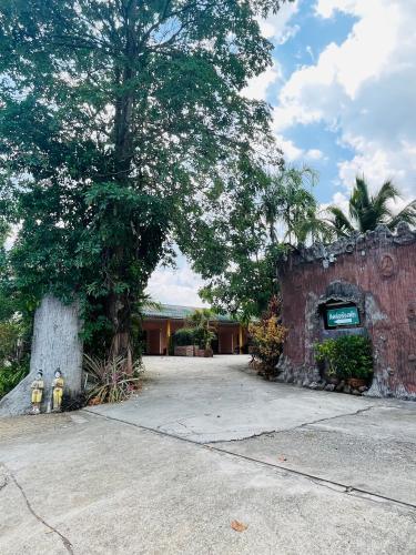 a brick building with a tree and a fire hydrant at Seven-in in Ban Khlong Chi Lat